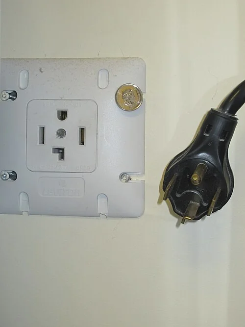 Four-slot NEMA 14-30 dryer receptacle beside its four-prong dryer plug.