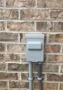 Guardian photograph of a closed outdoor equipment disconnect mounted on brick