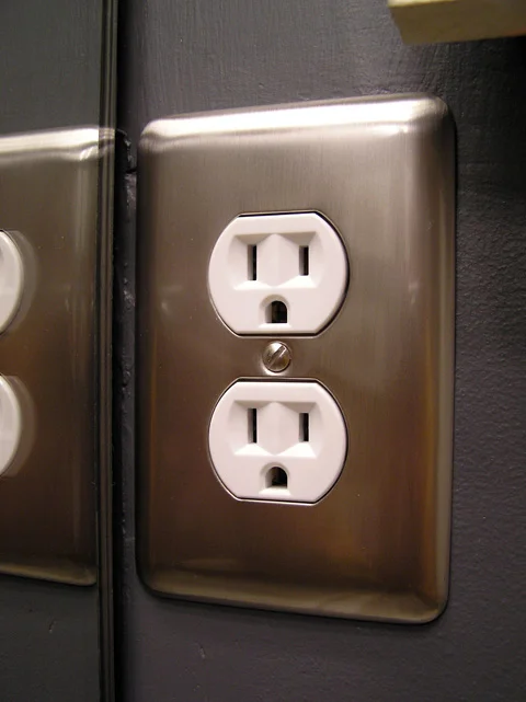 Photograph of a standard duplex electrical receptacle with a metal wall plate