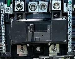 Guardian installation-stage photograph showing a main circuit breaker with the panel cover removed