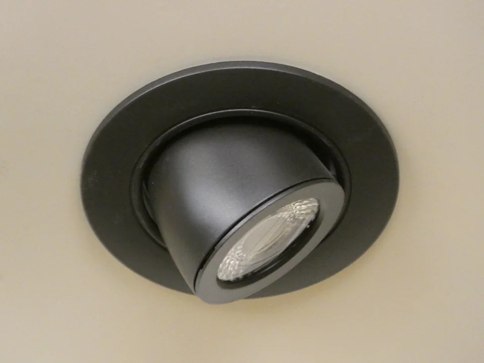 Round recessed ceiling light with an adjustable angled lamp.