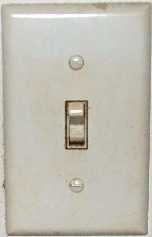 Photograph of a wall-mounted toggle light switch