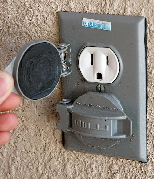 Photograph of an outdoor duplex outlet with individual hinged covers