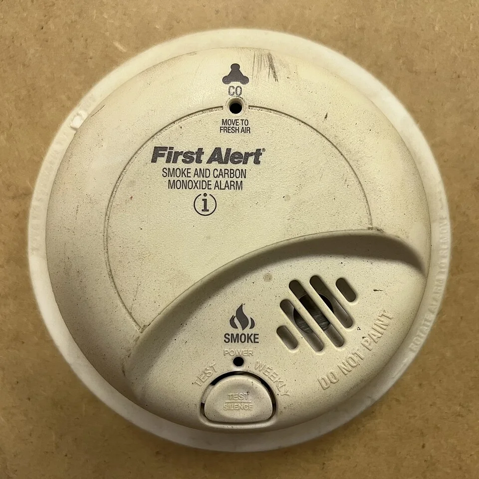 Combination smoke and carbon monoxide alarm with test button — licensed reference photograph.