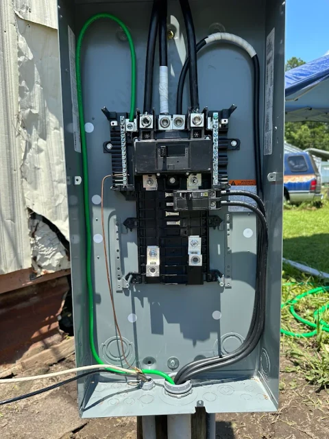 Service panel, another view. An outdoor service panel with its cover removed, showing breakers and wiring.