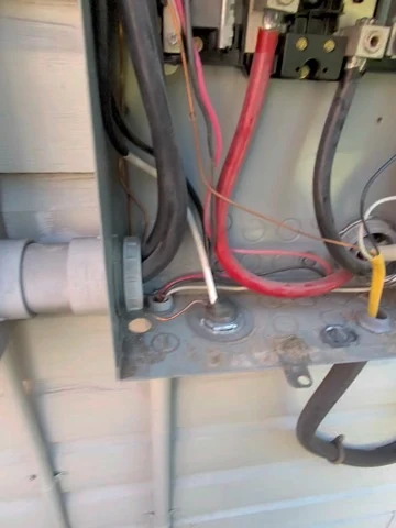 Service equipment detail. A close site photograph of service conductors during electrical work.