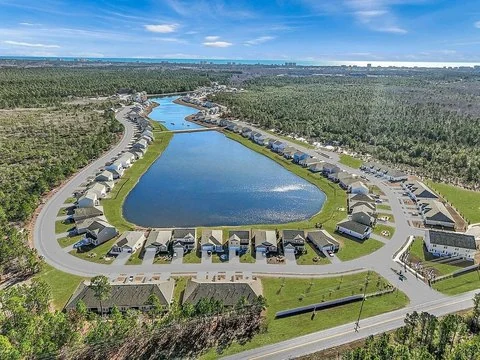 Aerial view of homes surrounding a neighborhood pond in Longs