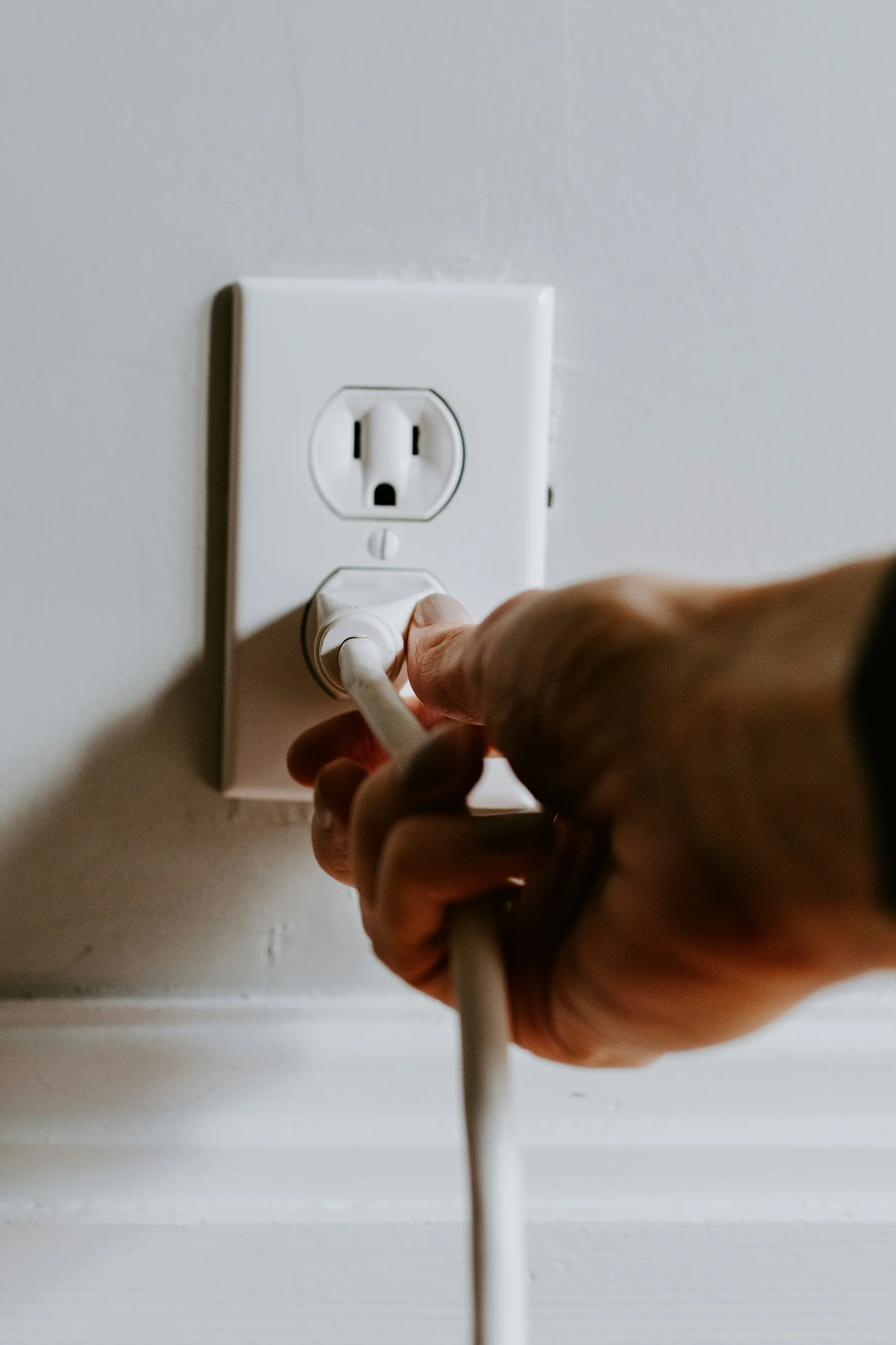 person holding white electric plug — stock photograph