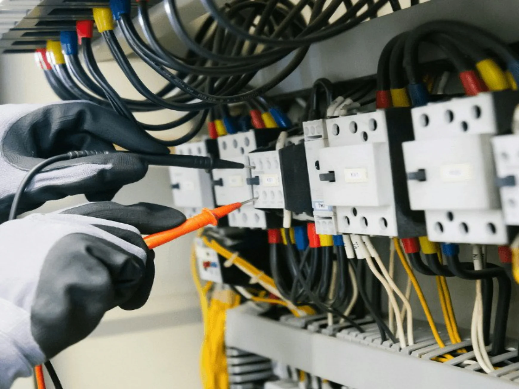 Electrician testing electrical panel with multimeter — stock photograph